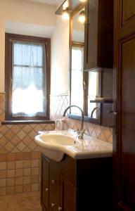 基亚恩尼Casa il Ponte的一间带水槽和镜子的浴室以及窗户。