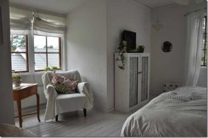 奥胡斯B&B Åvägen的卧室配有床、椅子和窗户。