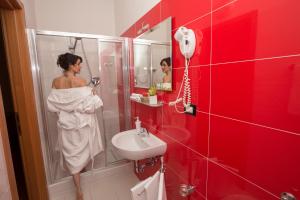 博洛尼亚阿卡迪米亚酒店的站在带水槽的浴室中的女人