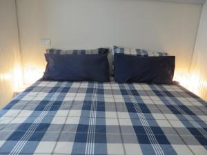 奥斯塔Alloggio turistico Maison S Anselme VDA Aosta CIR 0015的一张带蓝色和白色拼盘床单和枕头的床