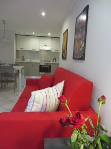 奥斯塔Alloggio turistico Maison S Anselme VDA Aosta CIR 0015的客厅里设有一张红色的沙发,配有厨房