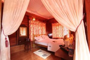 ChegātPugmarks Jungle Lodge的一间卧室,卧室内配有床和窗帘