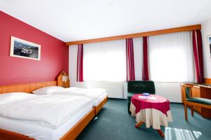 卢森堡克里斯托夫克伦姆的酒店客房设有两张床和红色的墙壁。