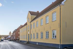 斯泰厄Hotel Residens Møen的街道边的黄色建筑