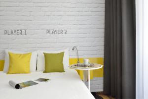 布达佩斯布达佩斯中心宜必思尚品酒店的一张带黄色和白色枕头的床和一张桌子