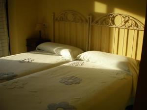 SelayaPosada laventa的卧室内的两张床,配有白色的床单和鲜花