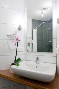 德累斯顿伽登乡村小别墅公寓式酒店的浴室水槽,花瓶上放着鲜花