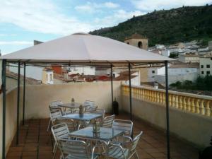 恩吉达诺斯Casa Rural Valle del Cabriel的一个带桌椅的伞下庭院