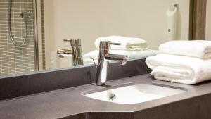 罗瑟勒姆Holiday Inn Rotherham-Sheffield M1,Jct.33, an IHG Hotel的浴室配有盥洗盆、镜子和毛巾