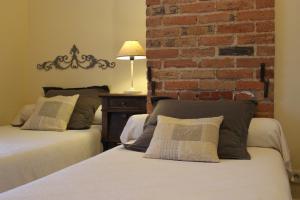 Chavagnes老面包店酒店的一间卧室设有两张床和砖墙