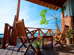 南知多海马卡吉玛艾斯竹亢酒店的一个带两把椅子和一张桌子的门廊,享有海景