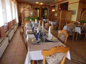 普图伊Motel Majolka的餐厅里一张长桌,配有白色的桌椅
