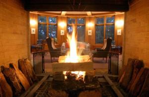 日光中禅寺金谷酒店的一个带椅子和桌子的房间的火坑