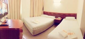 新加坡Golden Star Hotel的酒店客房设有两张床和电视。