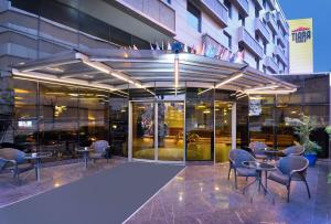 伯萨蒂拉温泉&SPA酒店的大楼前设有桌椅的餐厅