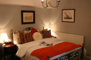 韦斯特伯里马与马夫住宿加早餐旅馆的一间卧室配有一张带红色毯子的床