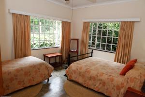 LobambaDown Gran's Self-Catering Cottage的一间卧室设有两张床和两个窗户。