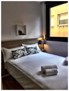 巴塞罗那格拉西亚公寓的卧室配有一张大白色床和窗户
