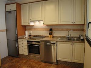厄尔梅达诺Villa Tejita的厨房配有白色橱柜、水槽和冰箱。