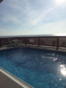 波因特普莱森特海滩风拂汽车旅馆的一个带两把椅子和木栅栏的游泳池