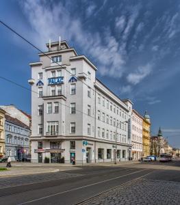 奥洛穆茨巴拉兹酒店的街上有蓝色标志的白色建筑