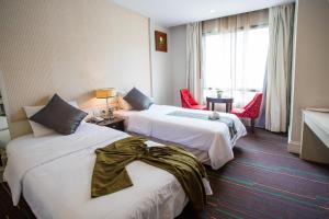 曼谷曼谷阿芙罗宾馆的酒店客房设有两张床和窗户。