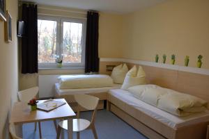 格尔利茨Villa Ephraim的酒店客房带两张床、一张桌子和一张桌子。