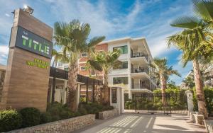 拉威海滩KR头衔海滩公寓酒店的一座楼前有棕榈树的酒店