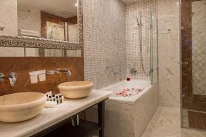 普雷绍夫Villa Plaza Boutique Hotel & Spa的浴室配有2个盥洗盆、浴缸和淋浴。