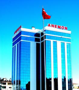 科尼亚Anemon Grand Konya Otel的上面有红旗的建筑