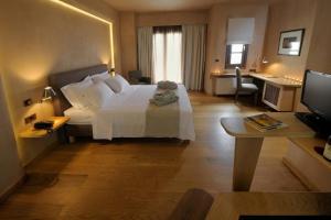 波尔塔里亚沃莱尼精品酒店加Spa的卧室配有一张白色大床和一张书桌