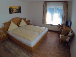 伦讷施塔特雷美尔豪斯酒店的一间卧室配有一张床、一张书桌和一个窗户。
