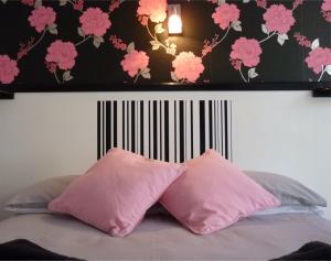 海斯廷斯Apollo Guest House的卧室内的一张带两个粉红色枕头的床