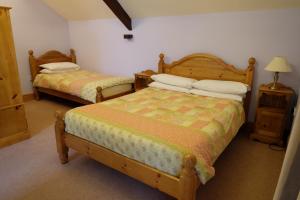 LlangorseBrynderwen的一间卧室配有两张床和一张带台灯的桌子