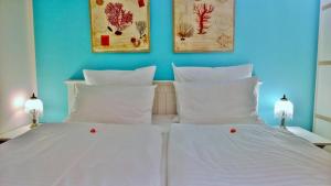 奥茨塞巴德·迪尔哈根奥斯提迪尔哈根公寓的一张带两个白色枕头的床和墙上的两张照片