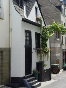 摩泽尔河畔的泽尔Ferienhaus DaVinci的白色的房子,有黑色的门和楼梯