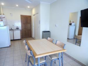 布兰卡港Apartamentos Güemes - Monoambientes的厨房以及带桌椅的用餐室。