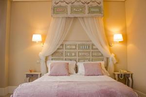 萨莫拉Ares Hotel的一间卧室配有一张带天蓬的大床