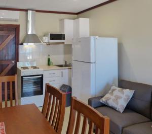 飞鱼湾科科斯帕当山林小屋公寓的带沙发和白色冰箱的厨房