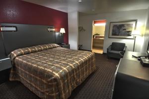 圣克拉拉圣克拉拉伊克诺旅店的配有一张床和一把椅子的酒店客房