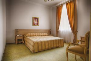 顿河畔罗斯托夫顿河畔罗斯托夫冬宫酒店的卧室配有床、椅子和窗户。