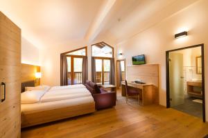 格罗萨尔迪欧菲尔酒店的一间卧室配有一张床、一张书桌和一面镜子
