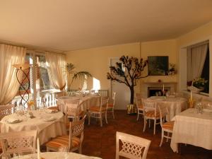 圣文森特奥林匹克酒店的一间设有白色桌椅和壁炉的用餐室