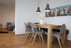 萨菲登安斯泰内嫩米尔达斯利希滕贝格东区别墅的餐桌,配有四把椅子和一幅狗画