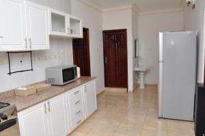 坎帕拉Muyenga Luxury Vacation Home的厨房配有白色橱柜和白色冰箱。