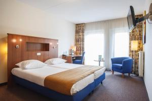 泽芬贝亨德博赫酒店的酒店客房,配有一张床和一张蓝色椅子
