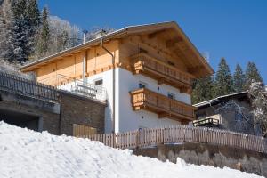 阿绍安贝格度假屋的雪顶上设有木制阳台的房子