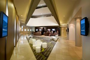 布里斯班布里斯班机场诺富特酒店的酒店大堂,设有白色椅子