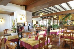 圣让皮耶德波尔拉蒙楚酒店的餐厅设有桌椅,配有粉红色和黄色的桌布