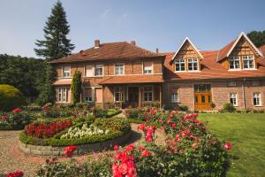 瓦伦多夫舒尔茨奥斯特霍夫酒店的一座带鲜花花园的大型砖屋